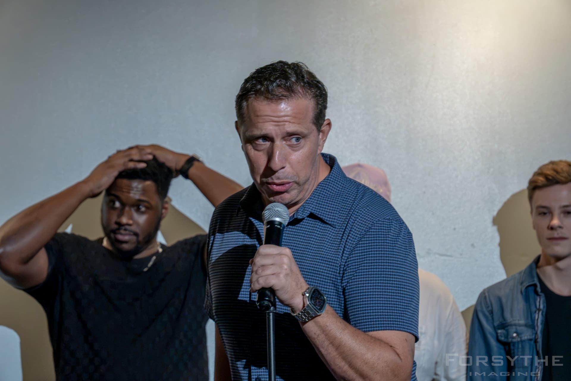 Aaron Bare speaking into a microphone during the live show