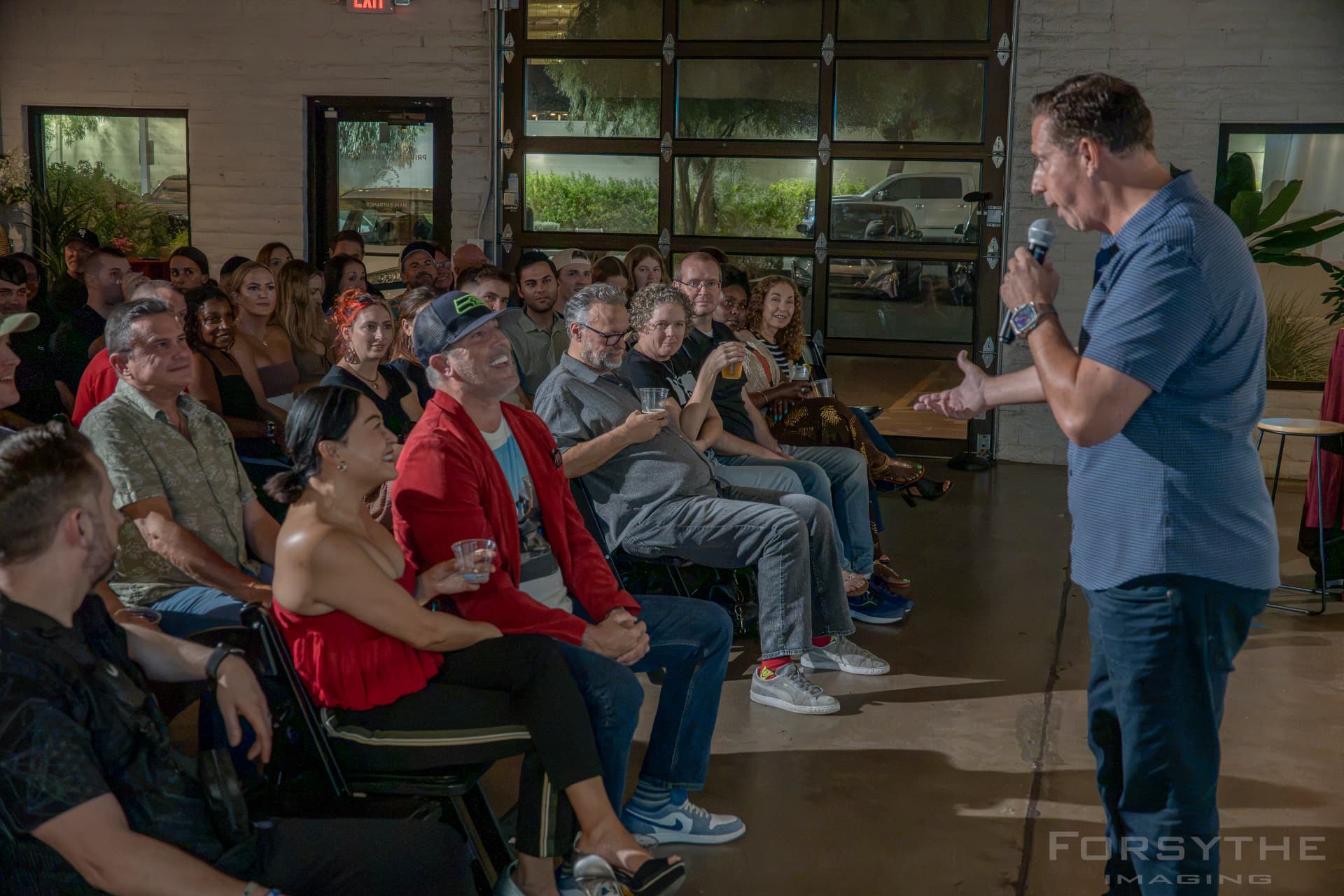 The hosts speaking with a seated live audience